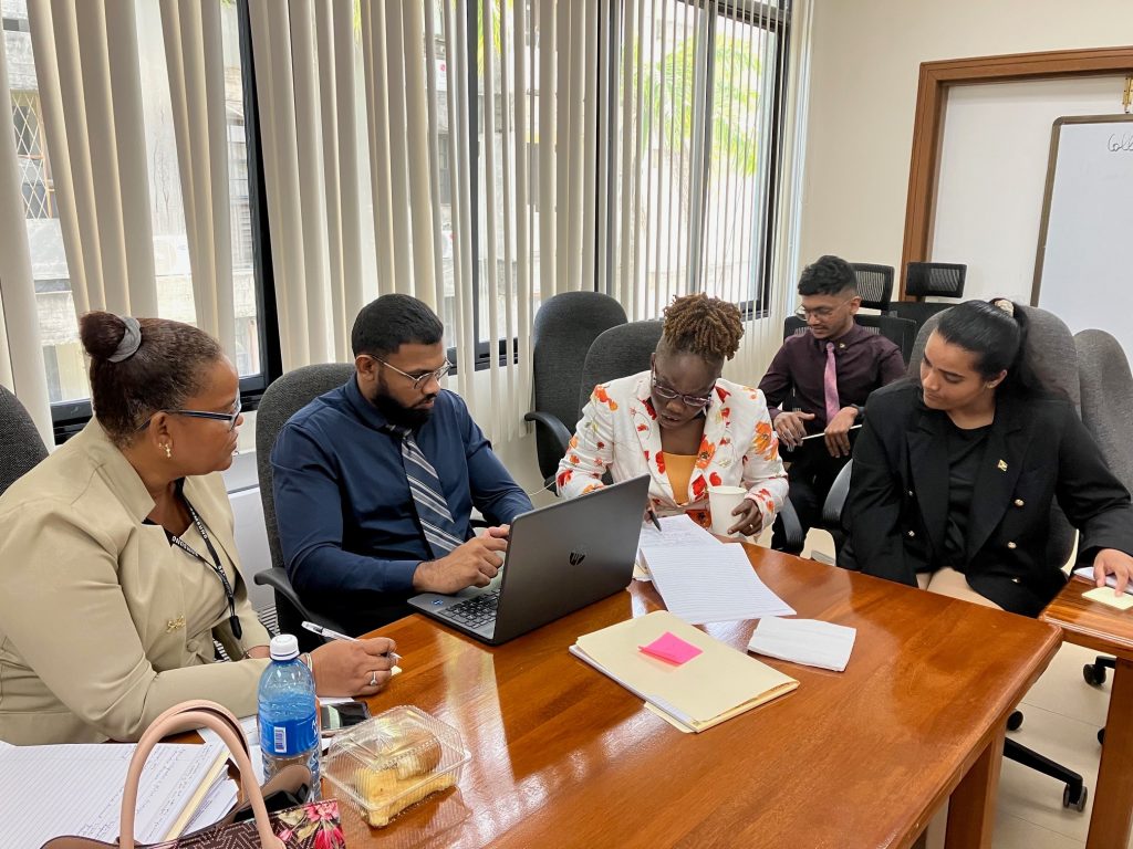 A man and a women at a table. They are reading a document together.