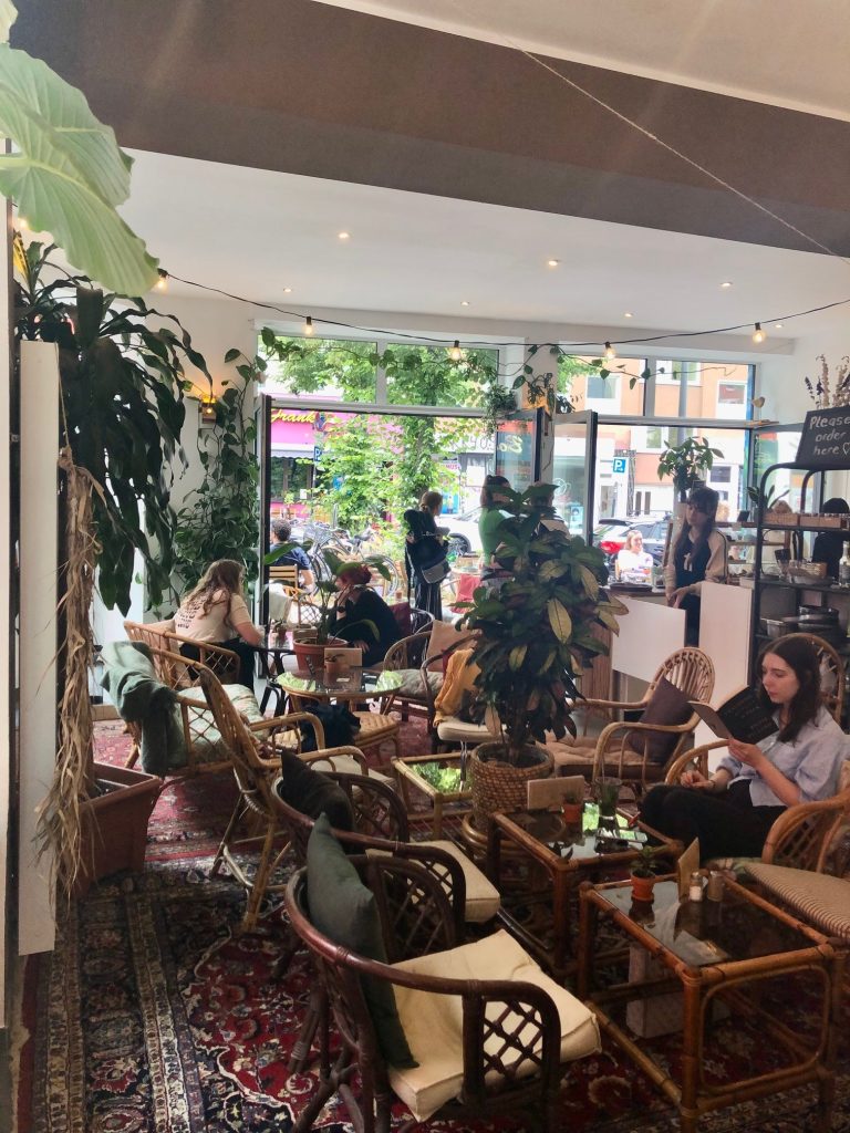 A cozy cafe decorated with bamboo furtniture and carpets.